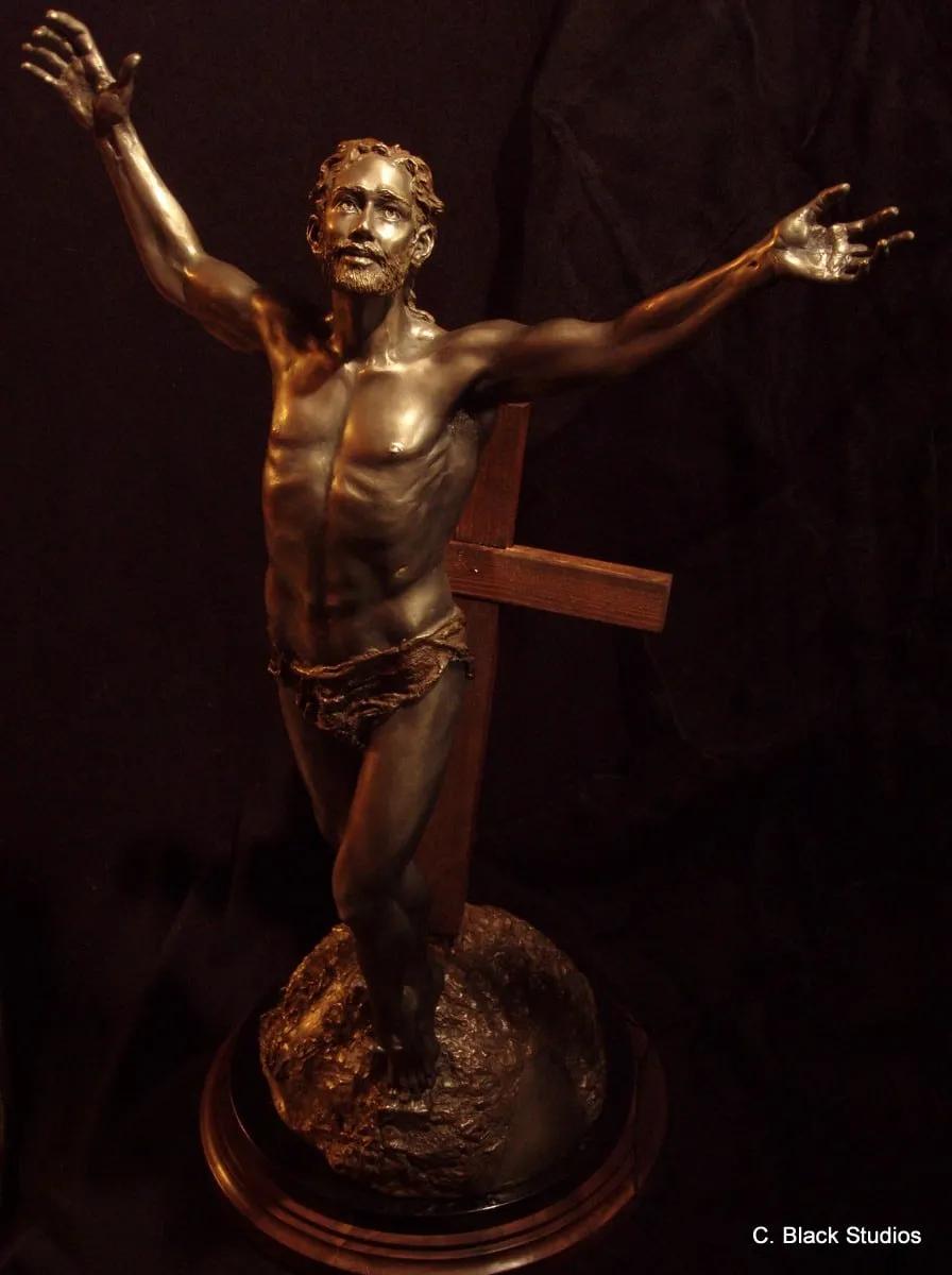 Resurrection, bronze sculpture by Colleen Black, a figure with raised arms standing before a wooden cross