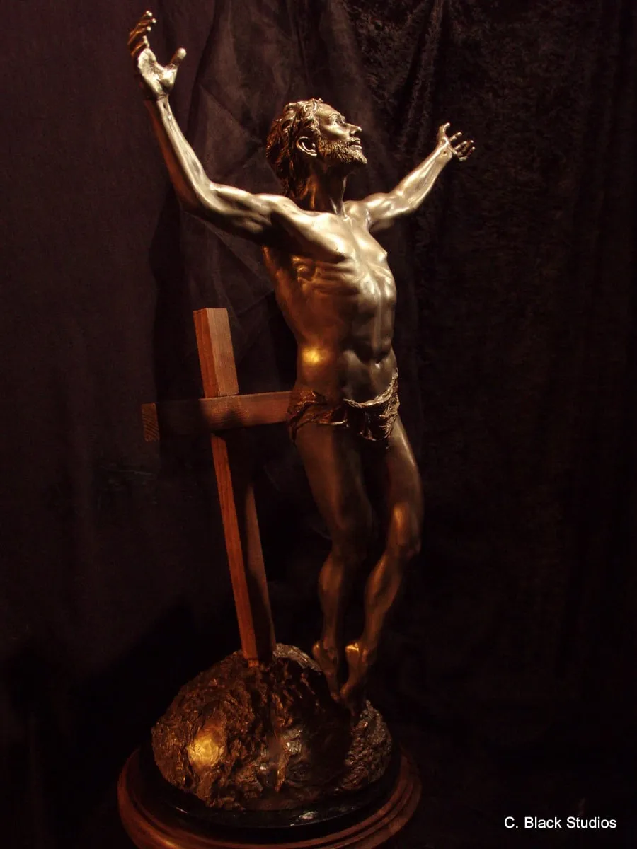 Resurrection, bronze sculpture by Colleen Black, the figure seen from the side with the wooden cross behind
