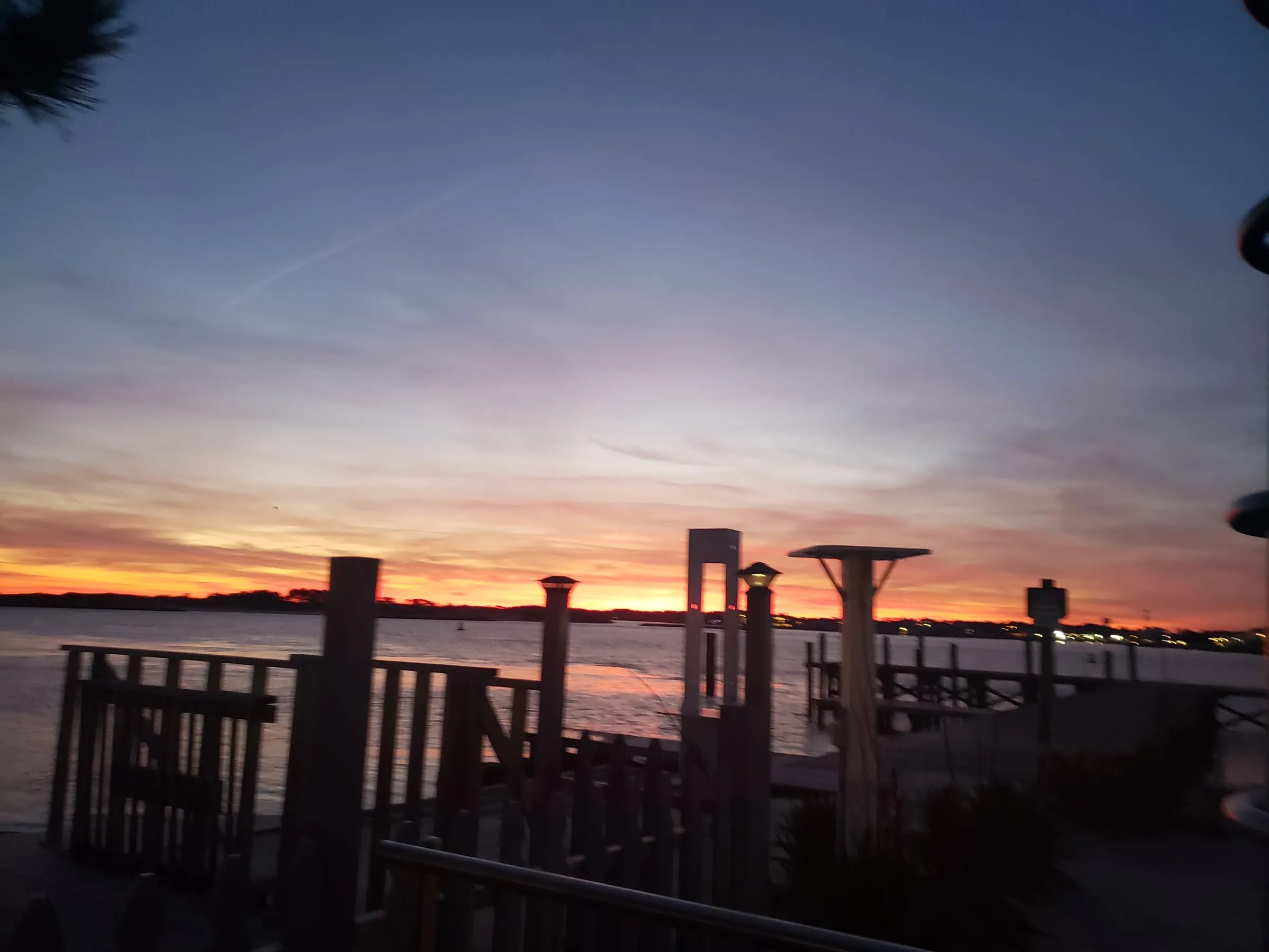 Sunset over a bay with wooden docks in silhouette